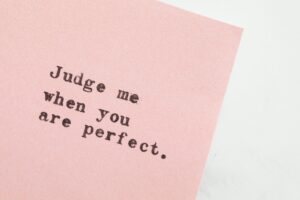 paper with the words, "judge me when you are perfect."